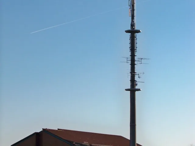 Fejállomás épülete és adótorony egy távközlési telephelyen
